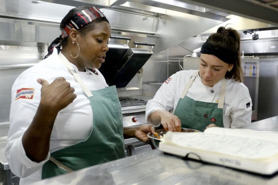Durham Chef Savannah Miller talks with a person in the kitchen on the set of Top Chef Season 21.