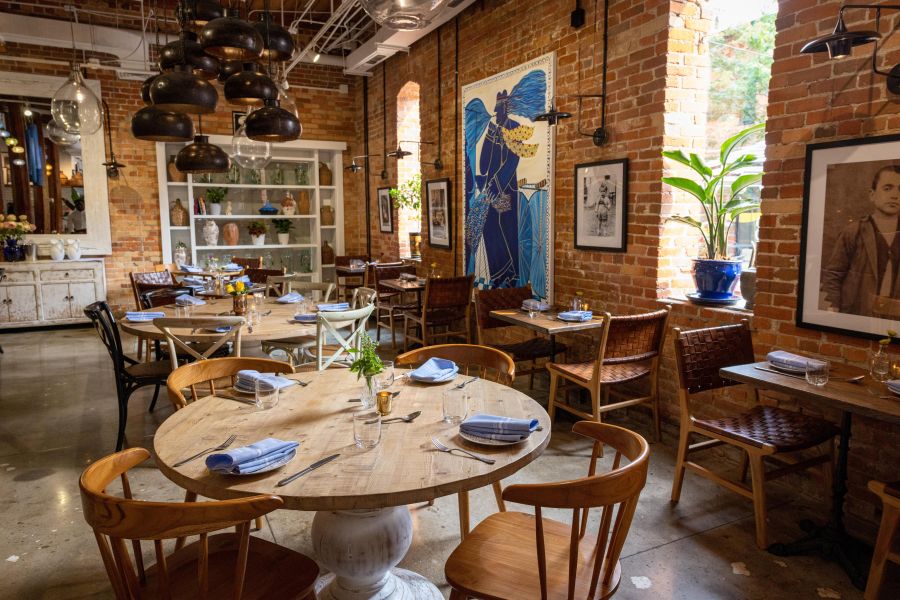 A naturally lit, rustic mediterranean restaurant interior at Nikos in Durham, NC