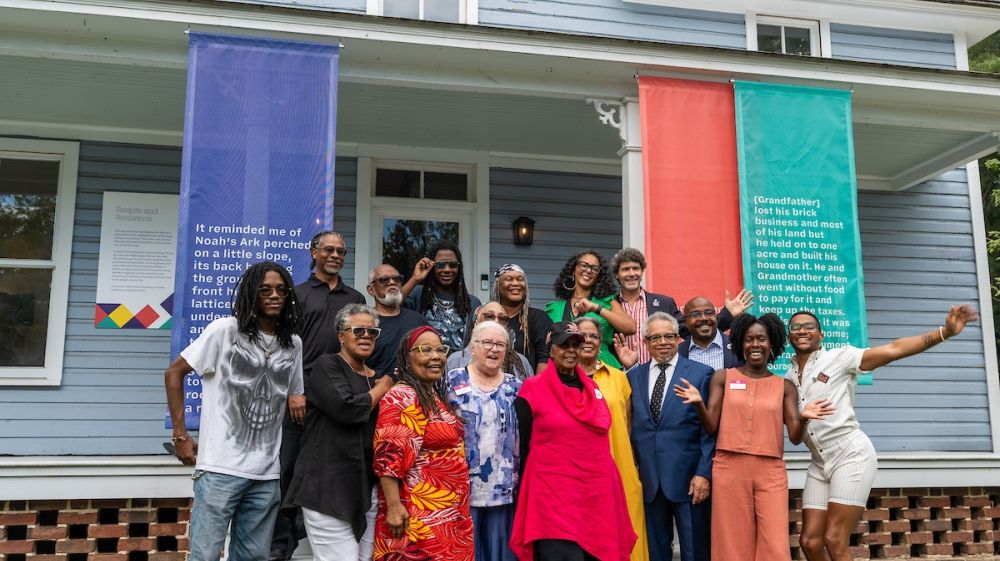 A crowd of people pose for the camera in front of the Pauli Murray Center in Durham, NC