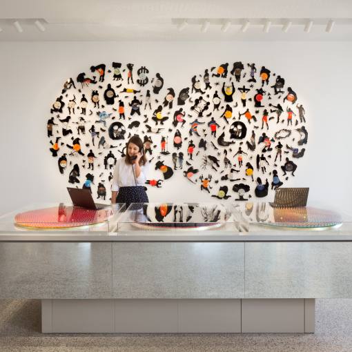 A woman on the phone stands behind the front desk of 21c Museum Hotel.