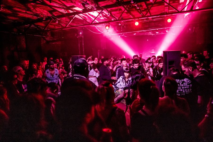 Concert goers crowd around a DJ at a dance party at The Fruit.
