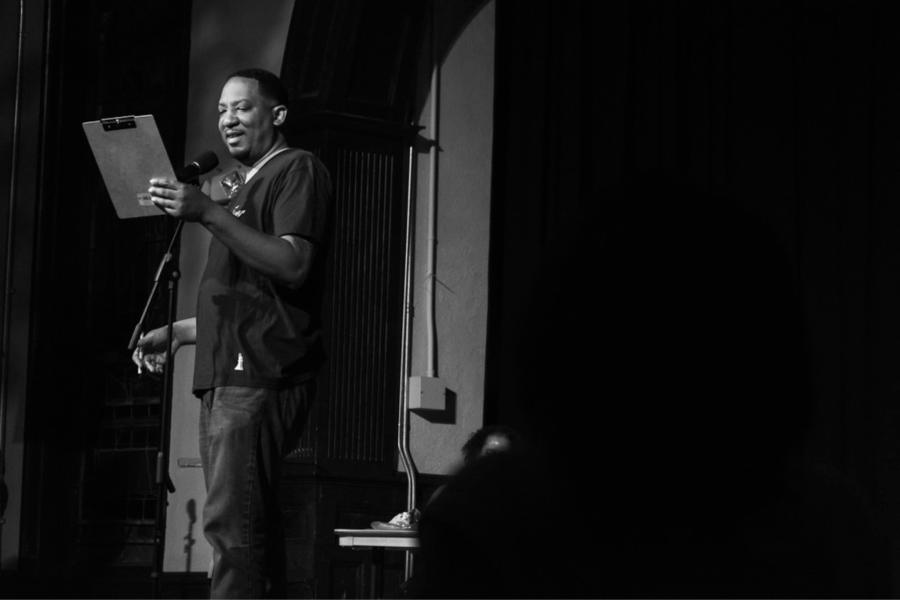 Durham author Dasan Ahanu reads on a stage.
