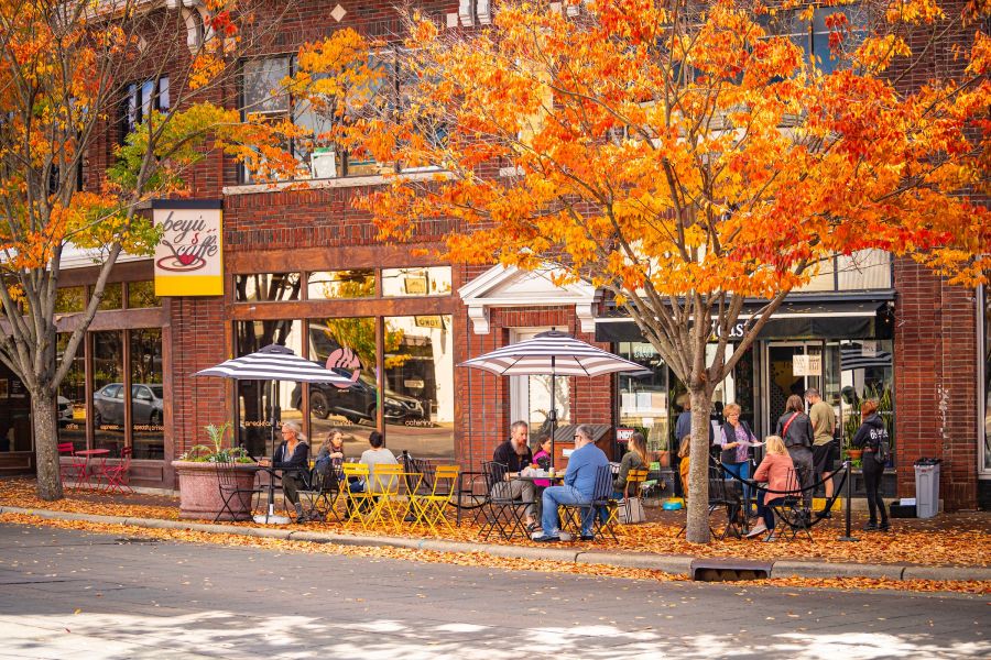 Customers in jackets and sweaters dine outside at Toast while enjoying the downtown autumn foliage
