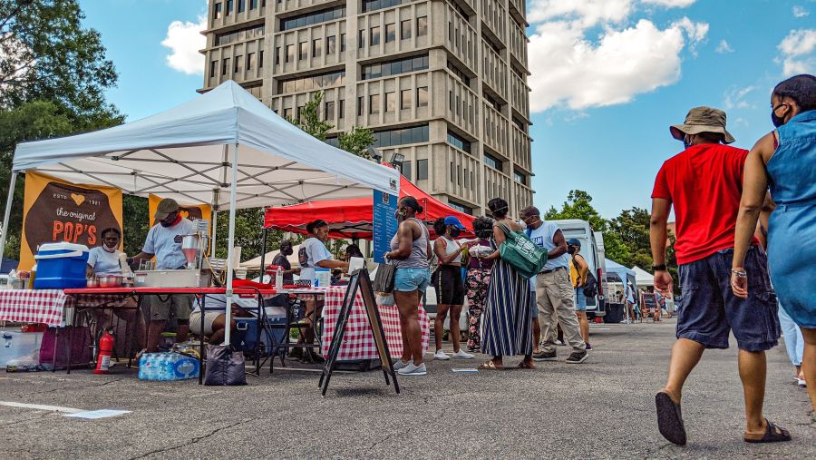 Shoppers walk on the streets by tents at the Black Farmers Market.