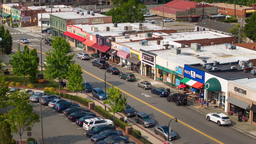 An areal view of Durham's Ninth Street shopping and dining district shows cars and shoppers passing on the busy street.