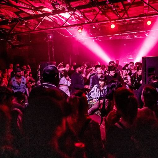 A large crowd gathers around a DJ booth at the Slingshot Music Festival, held at The Fruit, October 4th, 2024.