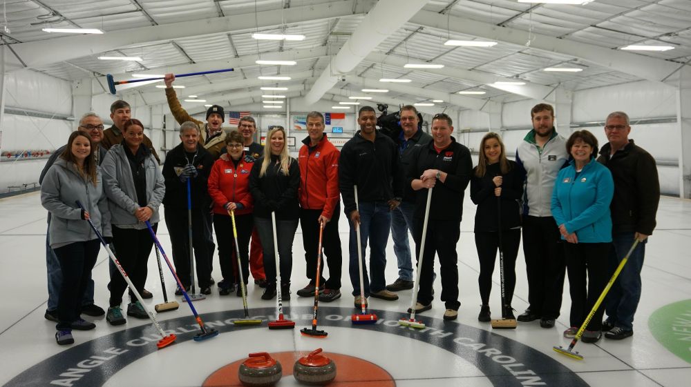 curling team posing on ice