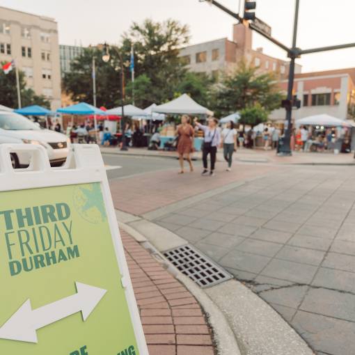 A sign directs walkers at Third Friday in Downtown Durham.