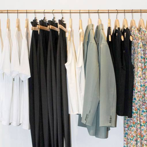 Earth toned clothes are lined up on a rack at Vert and Vogue in Durham, NC.