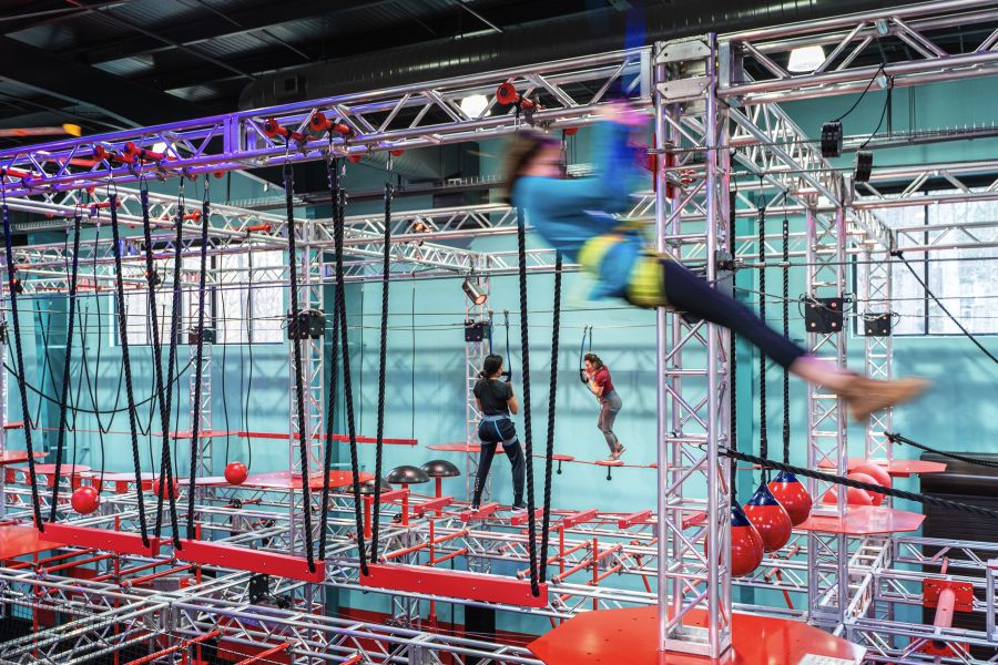 A guest flies by in a harness on an obstacle at OC Aerial in Durham.