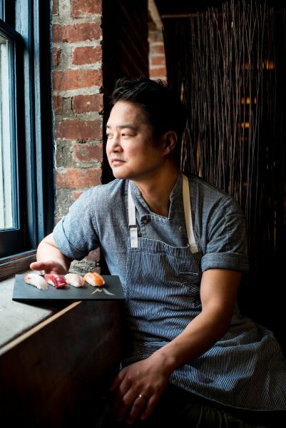 Chef Mike Lee looks out a window.